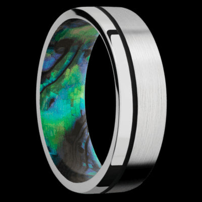7 mm wide/Flat/14K White Gold band with one 0.5 mm Off Center inlay of Black also featuring a Abalone sleeve.